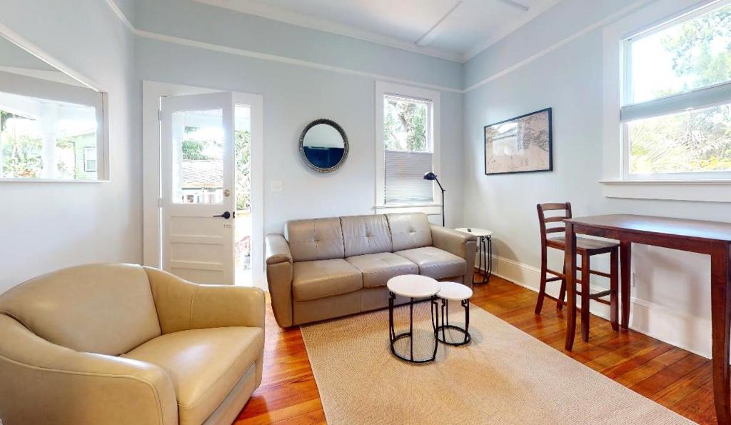 a living room with a couch and a table at Palm Paradise - Renovated 1891 Queen Anne - Historic DT Quarter Mi Stroll - Beach only 3 Mi in Saint Augustine