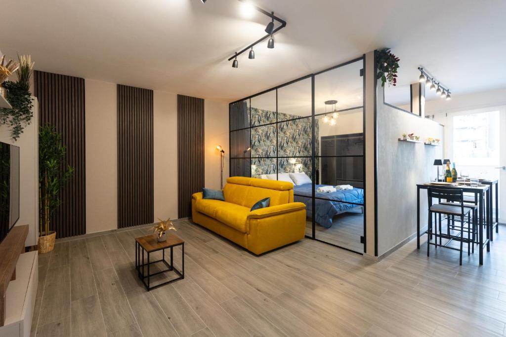 a living room with a yellow couch and a bedroom at Urban Chic Luxury Suite Apartments in Rome