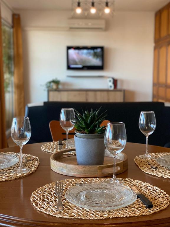 - une table avec des verres à vin et une plante en pot dans l'établissement L'Hermione, à Dienville