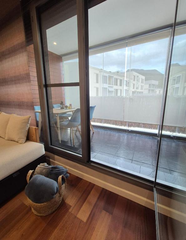 a living room with a large window and a couch at Las Margas Apartamento in Sabiñánigo