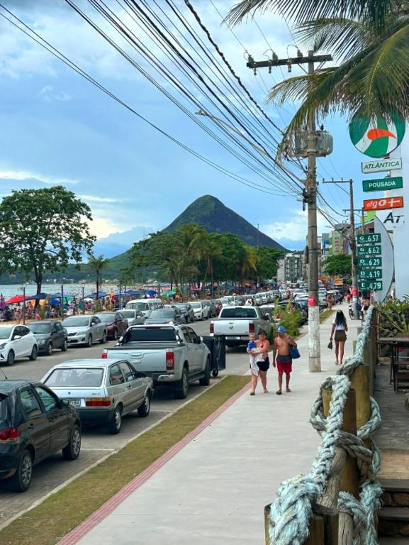 a busy street with cars parked in a parking lot at Pousada e restaurante veredas in Piúma