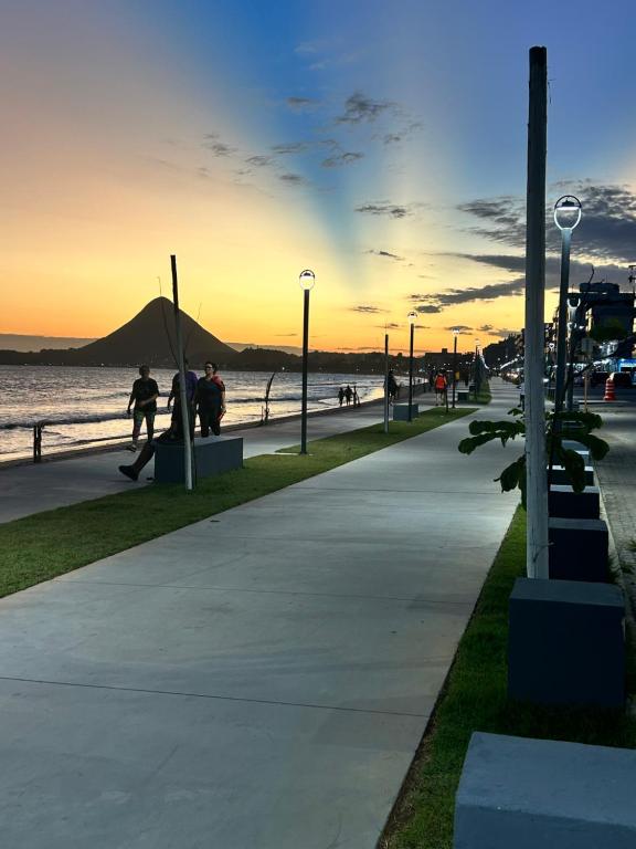 una persona che cavalca uno skateboard su un marciapiede vicino all'acqua di Pousada e restaurante veredas a Piúma