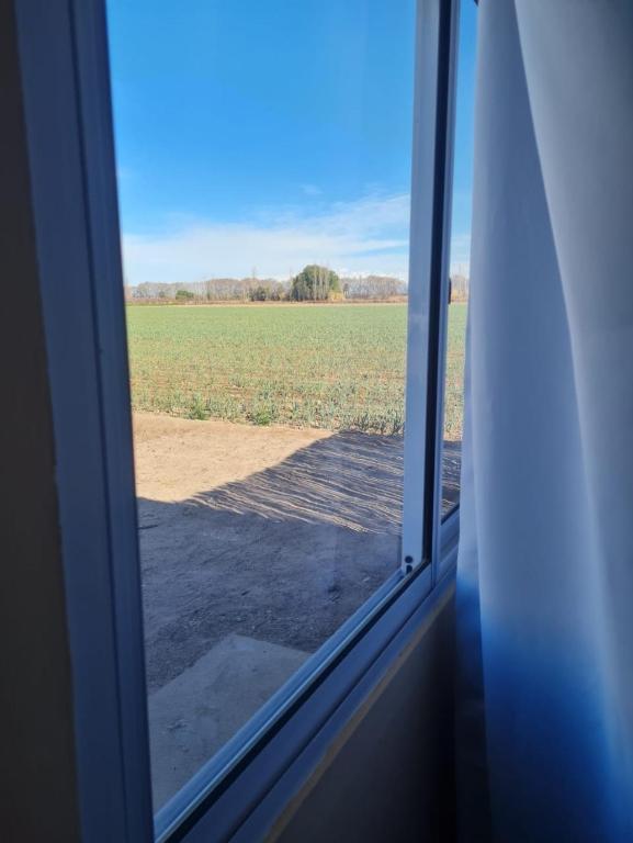 einen Blick auf ein Feld aus einem Fenster in der Unterkunft Pasadena in Junín