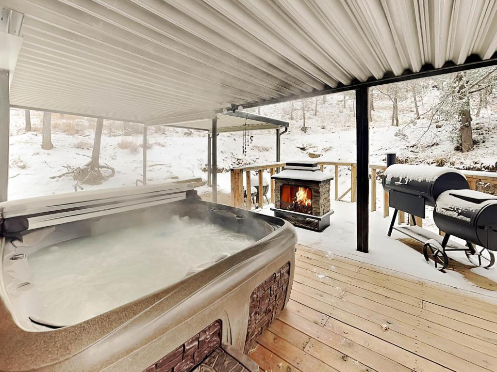 una vasca idromassaggio all'aperto con camino nella neve di Docs Den a Ruidoso