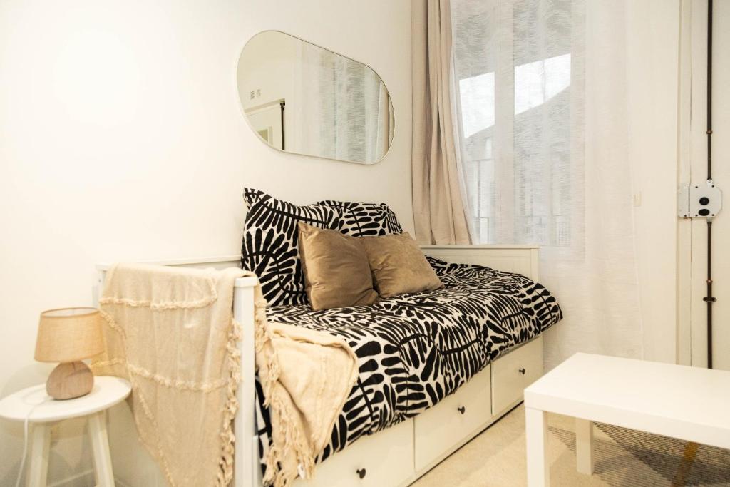 - une chambre avec un canapé à motifs zébrés et un miroir dans l'établissement Studio Stade de France 26 pour 2 personnes, à Saint-Denis