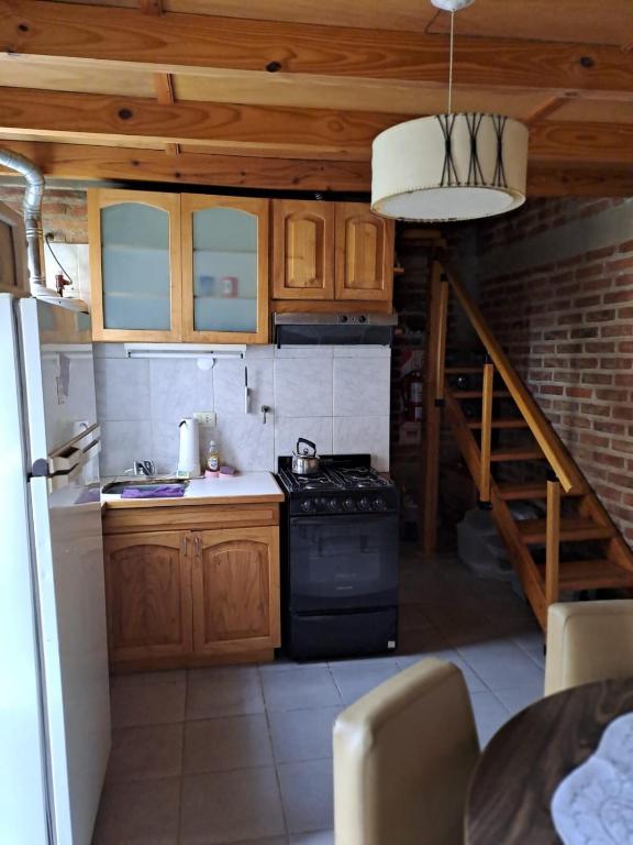 a small kitchen with a stove and a staircase at Departamento Ruca che in Neuquén