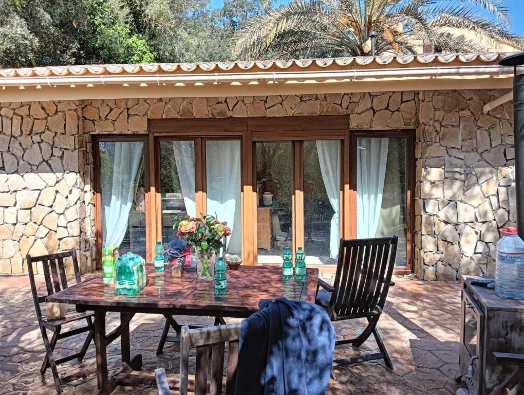a wooden table with chairs in front of a stone house at Casita Balear Sa Coveta in Algaida