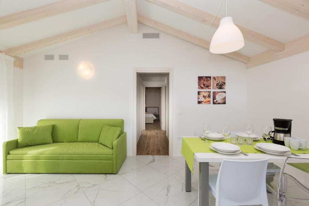 Una sala de estar con un sofá verde y una mesa. en Residence Klima House de Vilos, en Arco