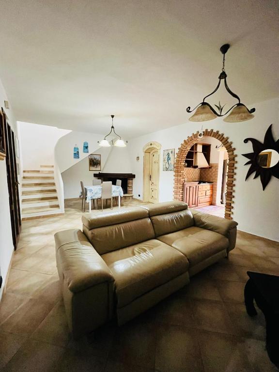 a living room with a couch and a piano at Angelica's beachside apartment in Porto Columbu - Perdʼe Sali