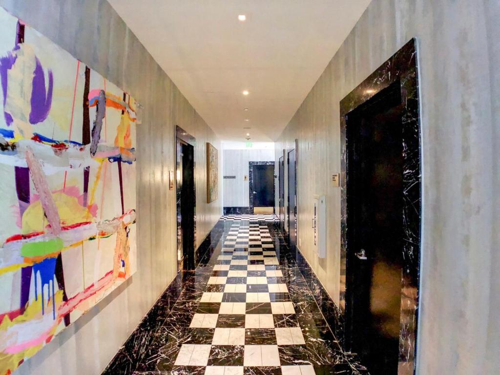 a hallway with a checkered floor and paintings on the walls at Sky High Penthouse Corner 2BR 2BA Icon Brickell in Miami