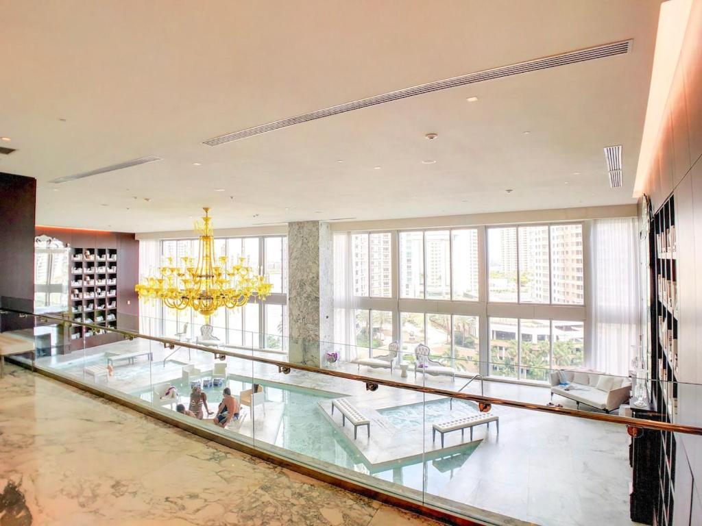 a large lobby with a glass floor and a chandelier at Sky High Penthouse Corner 2BR 2BA Icon Brickell in Miami