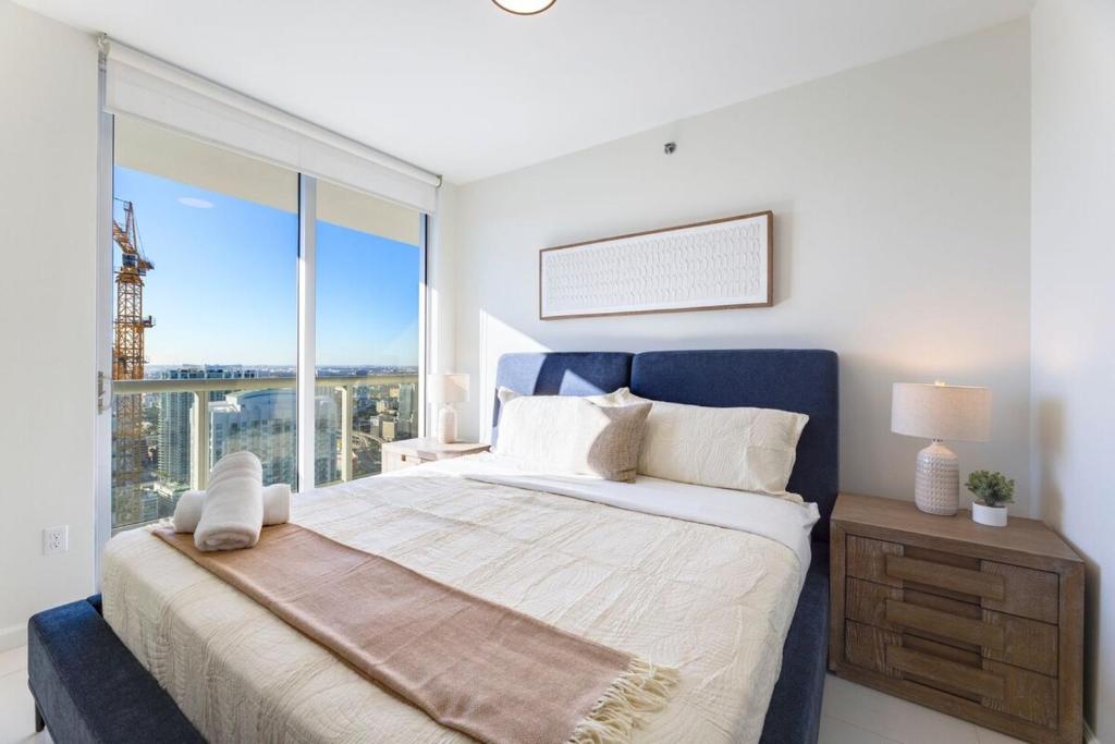 a bedroom with a large bed and a large window at Sky High Penthouse Corner 2BR 2BA Icon Brickell in Miami