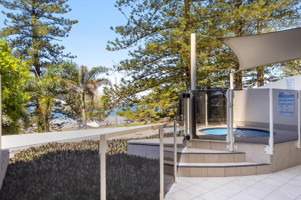 a jacuzzi outside of a building with trees at ZANZ205- Exclusive Outdoor Spa with Ocean Glimpses in Mooloolaba
