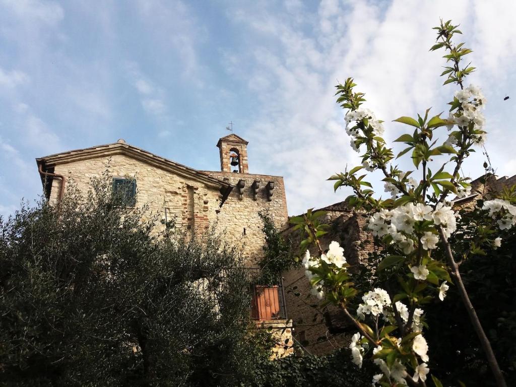 un antiguo edificio con un campanario encima en Casa intera con giardino, en Mantignana