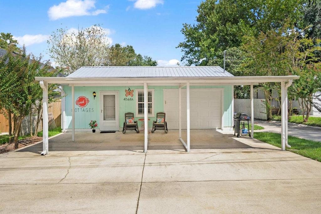 a small house with a porch and two chairs at Dog Friendly Cottage Just North of Historic St Aug in Saint Augustine