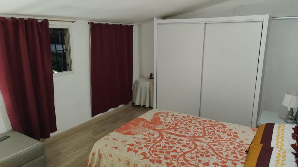 a bedroom with a bed with red curtains at XayEm Apart in Villa Carlos Paz