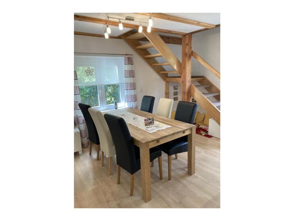 a dining room with a wooden table and chairs at Holiday home chalet on the castle hill in Brotterode-Trusetal