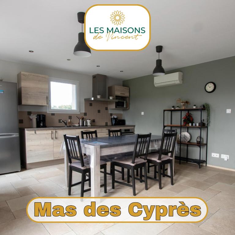 - une cuisine avec une table à manger et des chaises dans l'établissement Mas des Cyprès, clim - jardin en Camargue, à Arles