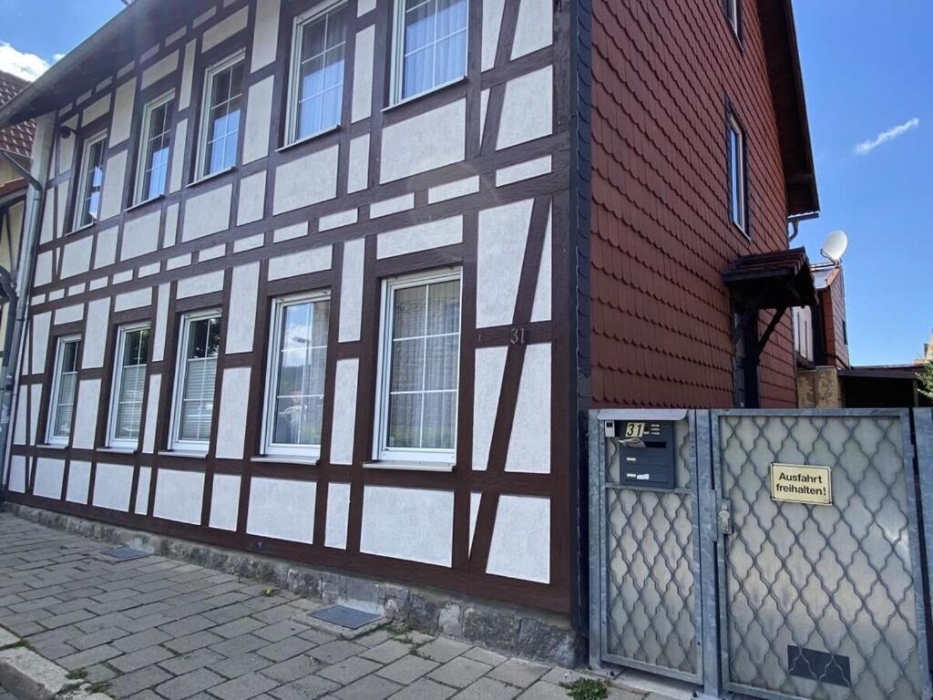a black and white building with a fence in front of it at Holiday apartment on the Anger in Wernigerode