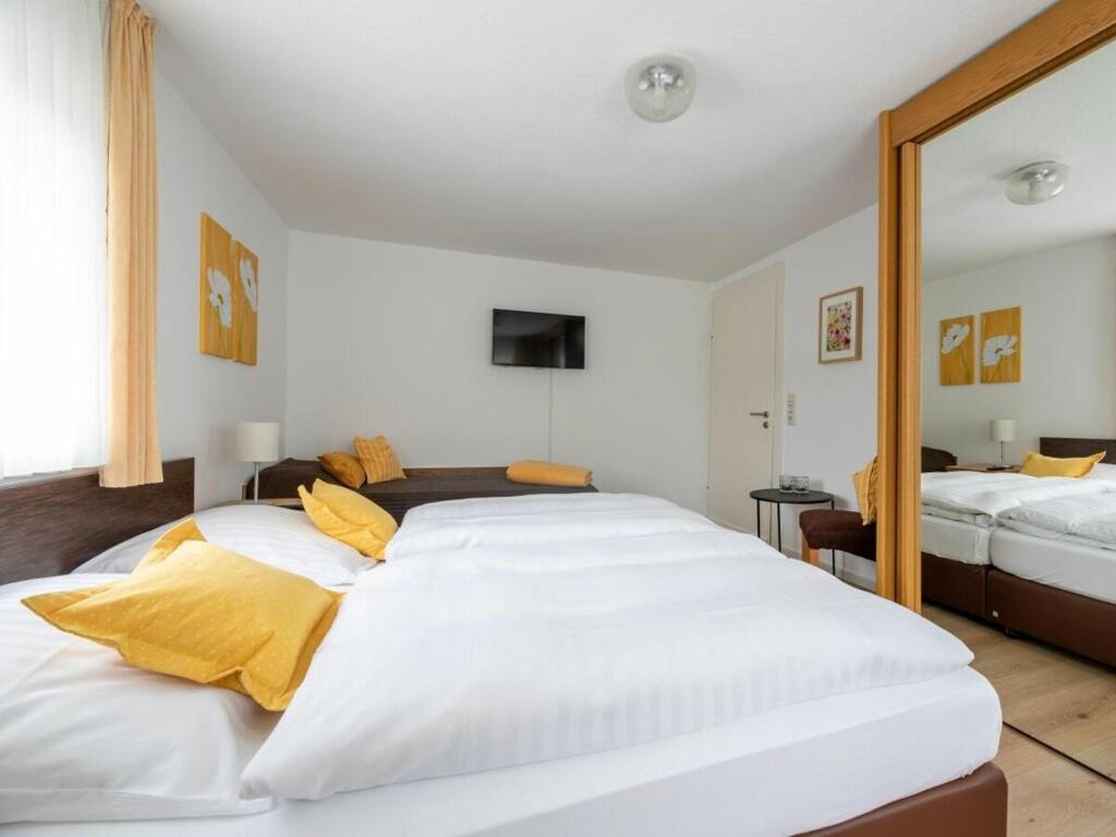 a bedroom with a large white bed with yellow pillows at Panorama Modern retreat in Eslohe