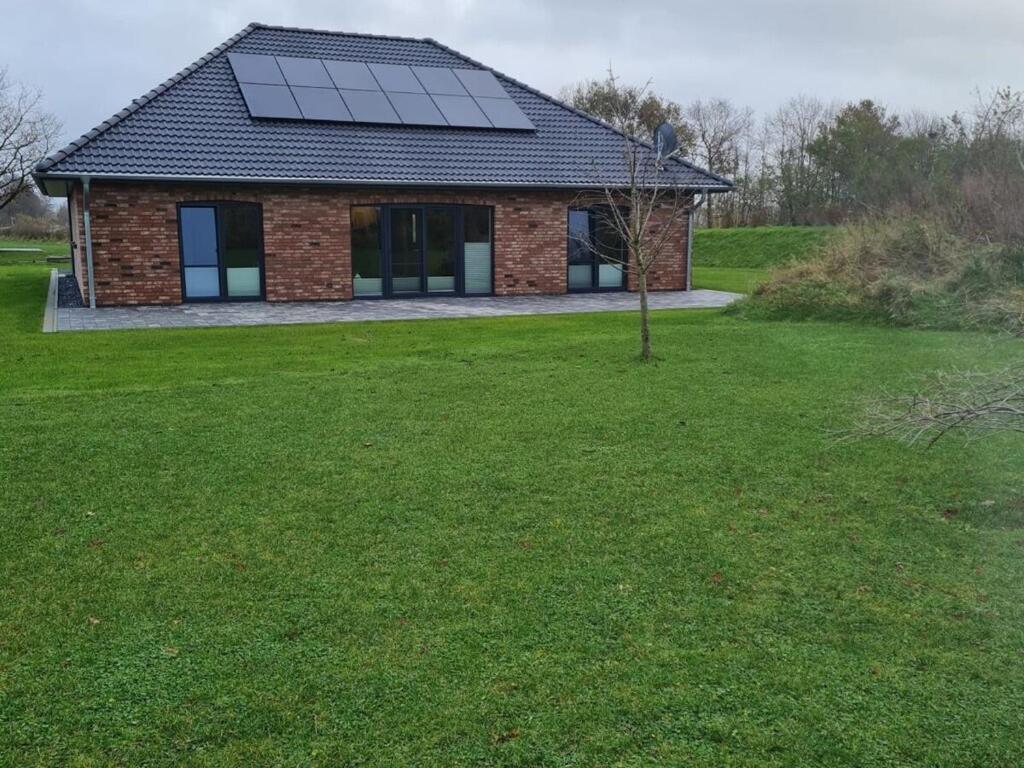 a house with a solar panel on top of a yard at Holiday home Stieglund in Jörl