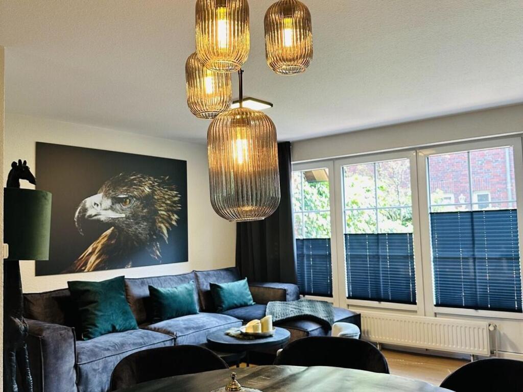 un salon avec un canapé bleu et des lustres dans l'établissement Raceweide - MarBi Alles inbegrepen, à Dangast