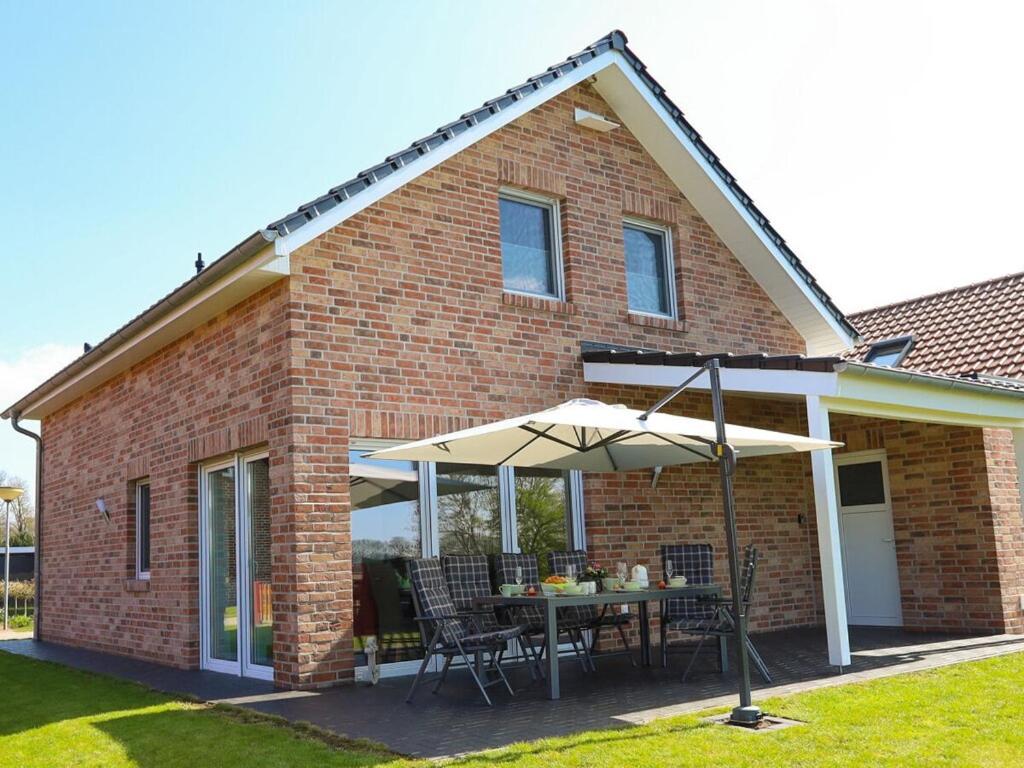 a house with a table and an umbrella at Marinapark 147 Modern retreat in Walchum