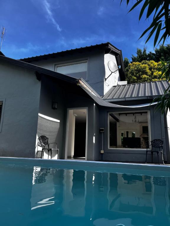 a house with a swimming pool in front of a house at Casa Balcón del Golf in Sierra de los Padres