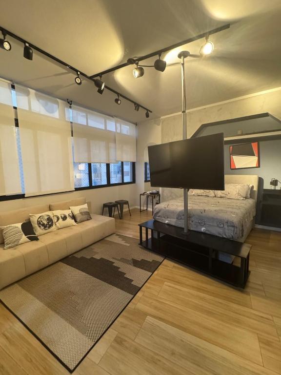 a living room with a couch and a flat screen tv at Kitnet 1109 in São Vicente