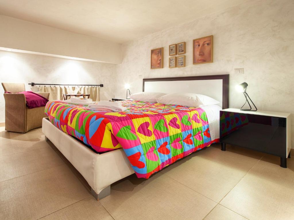 1 dormitorio con 1 cama grande con una manta colorida en HT Residence Maximus, en Roma