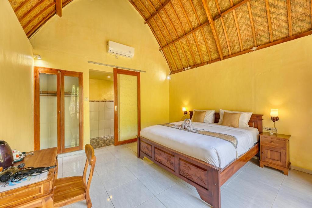 una camera da letto con un letto grande e un bagno di Maharga Bungalows a Nusa Penida