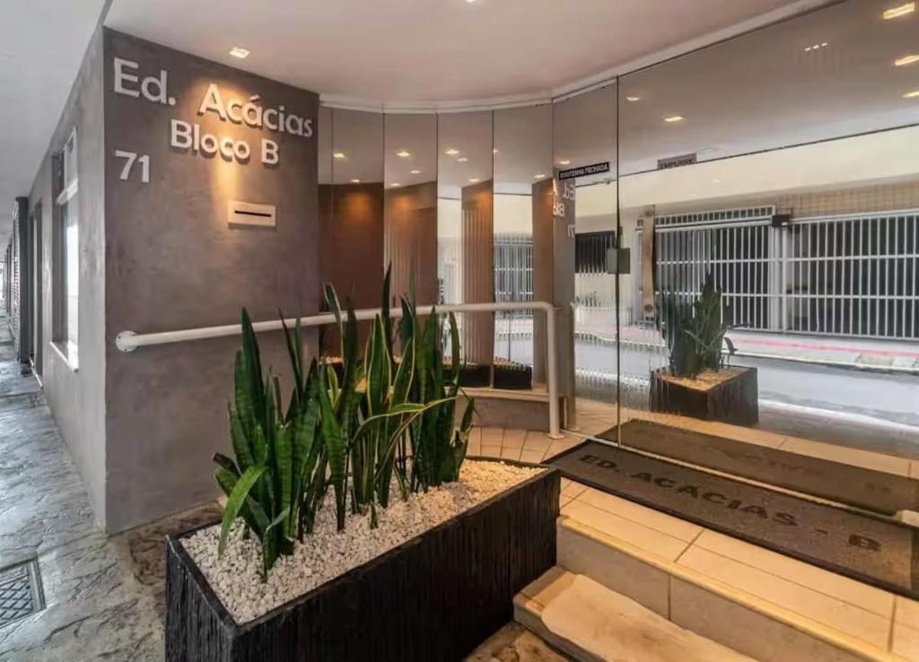 a lobby of an office building with plants at Ed. Acácias B in Balneário Camboriú
