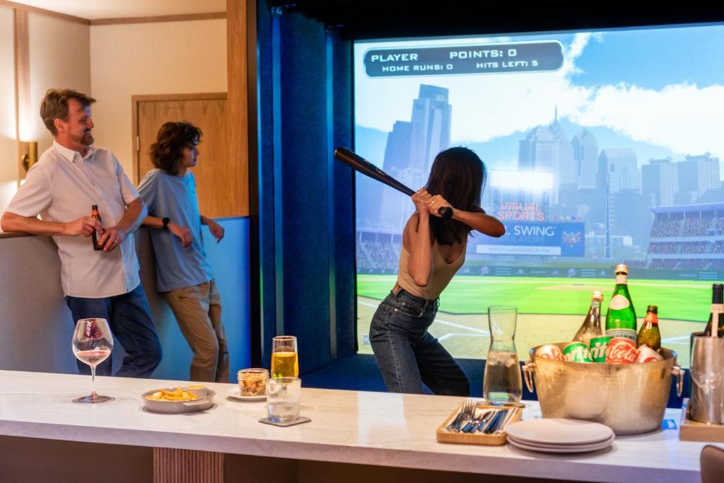 a woman holding a baseball bat in front of a screen at Lotus Honolulu at Diamond Head in Honolulu