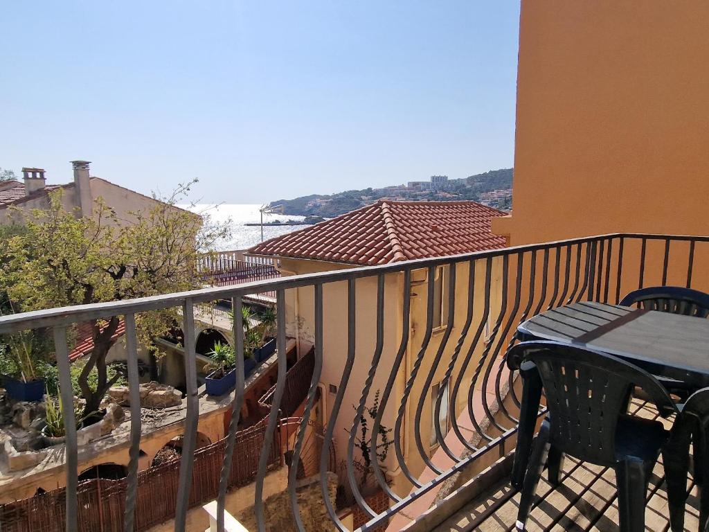 - un balcon avec une table et un banc dans un bâtiment dans l'établissement Banyuls-sur-Mer : Appartement T3 central avec terrasse - 5 pers - FR-1-309-58, à Banyuls-sur-Mer