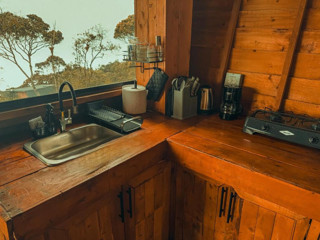 een aanrecht met een wastafel en een raam bij Peregrino Glamping 1 in Medellín