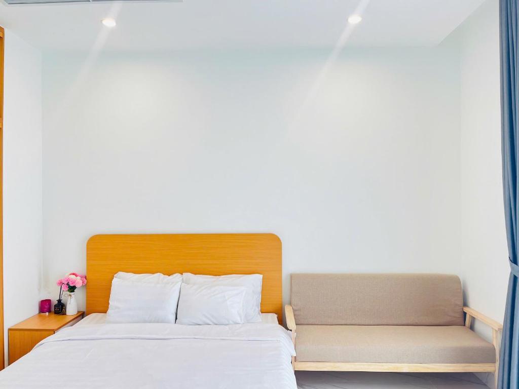 - un lit et un banc dans une chambre dans l'établissement May Homes - Studio Beverly Vinhomes Grand Park, à Long Bình