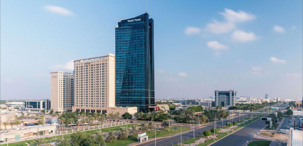 a tall building in the middle of a city at Dusit Thani Abu Dhabi in Abu Dhabi