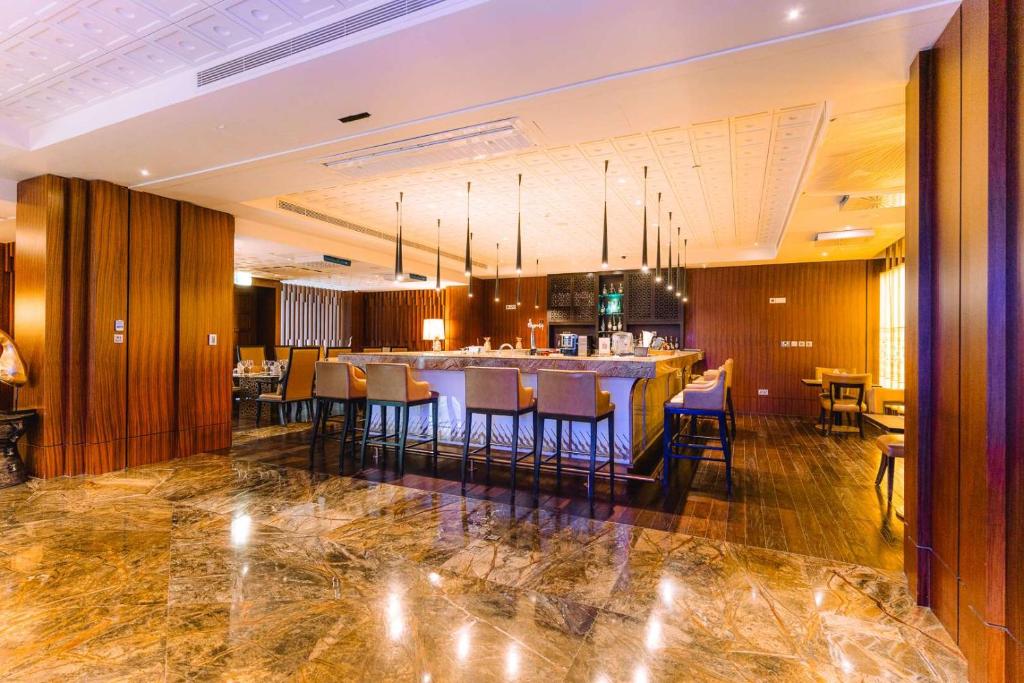a lobby with a bar with chairs and tables at Dusit Thani Abu Dhabi in Abu Dhabi