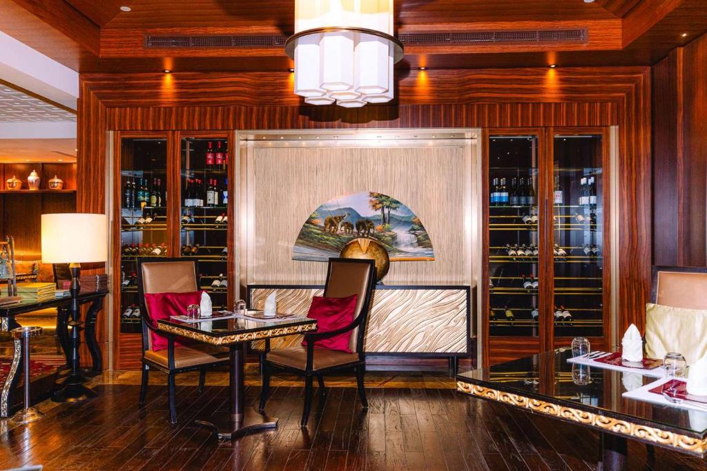 a dining room with a table and chairs and wine racks at Dusit Thani Abu Dhabi in Abu Dhabi