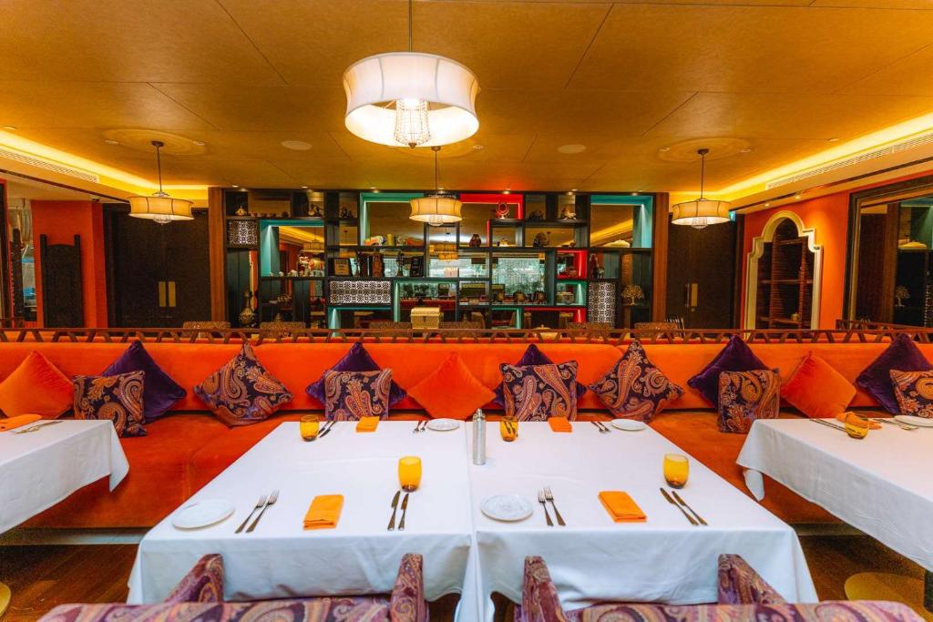 a dining room with two tables and a bar at Dusit Thani Abu Dhabi in Abu Dhabi