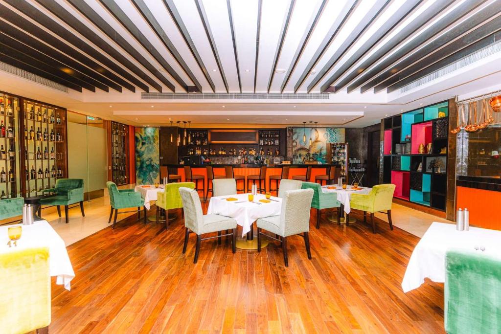 a restaurant with tables and chairs and a bar at Dusit Thani Abu Dhabi in Abu Dhabi