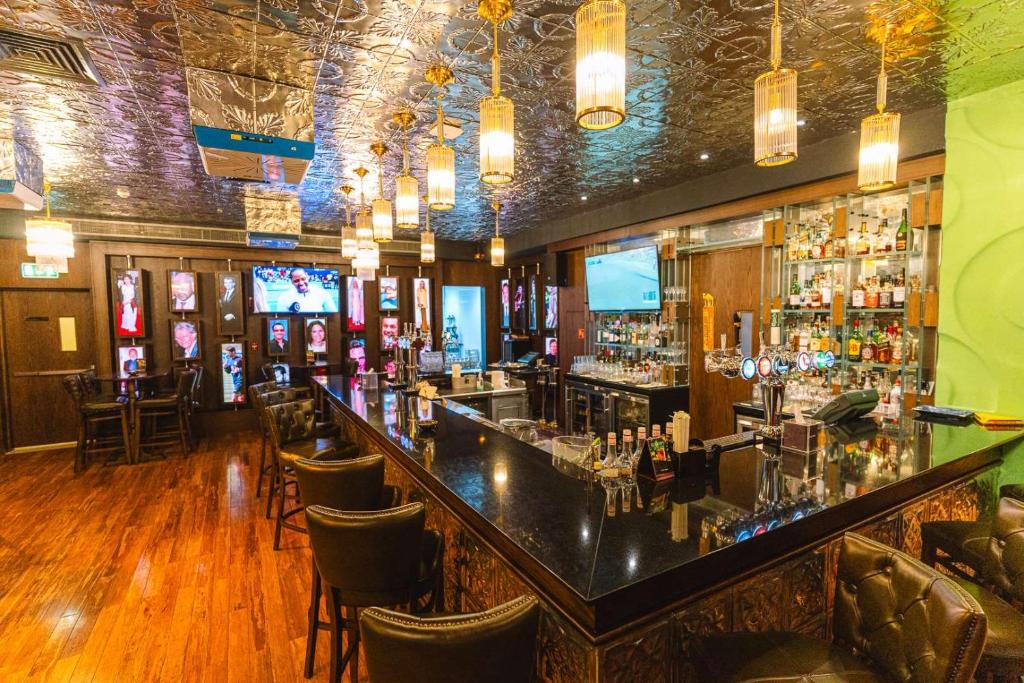 a bar in a restaurant with a counter and chairs at Dusit Thani Abu Dhabi in Abu Dhabi