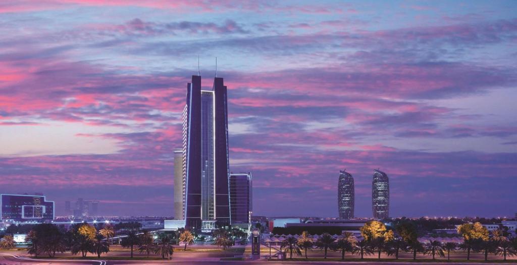 a city skyline with tall skyscrapers under a cloudy sky at Dusit Thani Abu Dhabi in Abu Dhabi