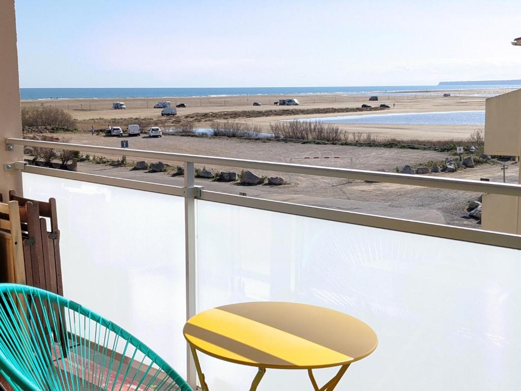 un balcon avec une chaise jaune et une vue sur la plage dans l'établissement Bel appartement T2 climatisé avec piscine et parking à 250m de la plage - FR-1-797-9, à Port-la-Nouvelle
