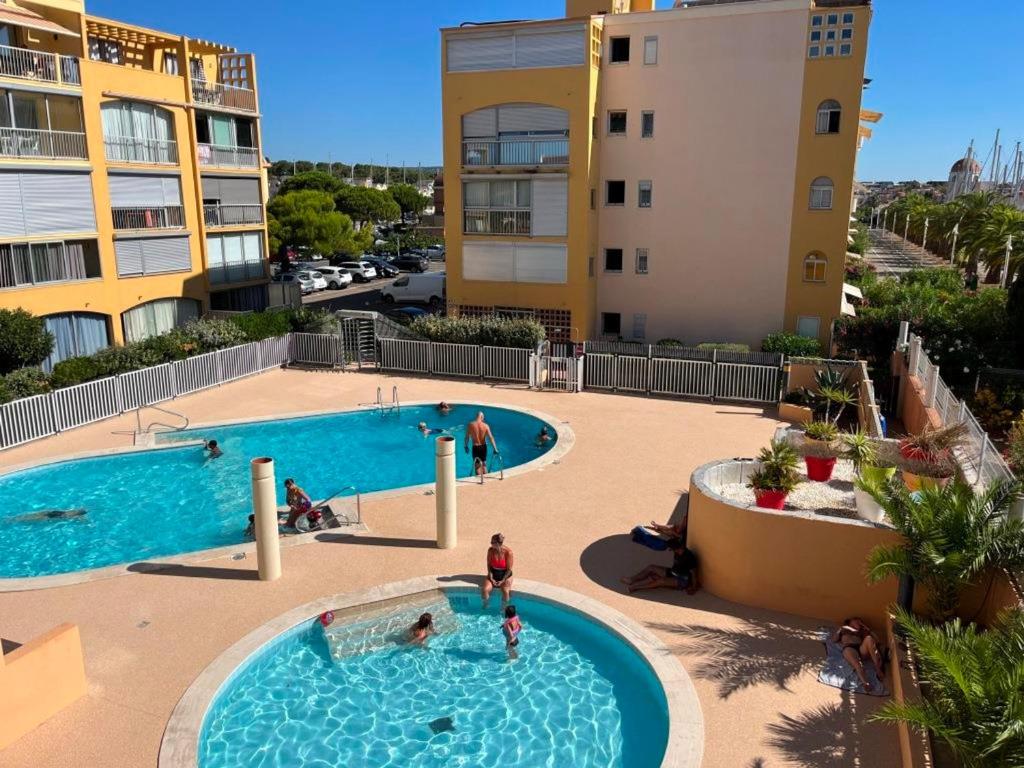 - une piscine dans un complexe avec des personnes dans l'établissement Gruissan: T3, 4 Pers, Piscine, Parking, Proche Commerce, Environnement Calme, Accès Plage - FR-1-796-14, à Gruissan