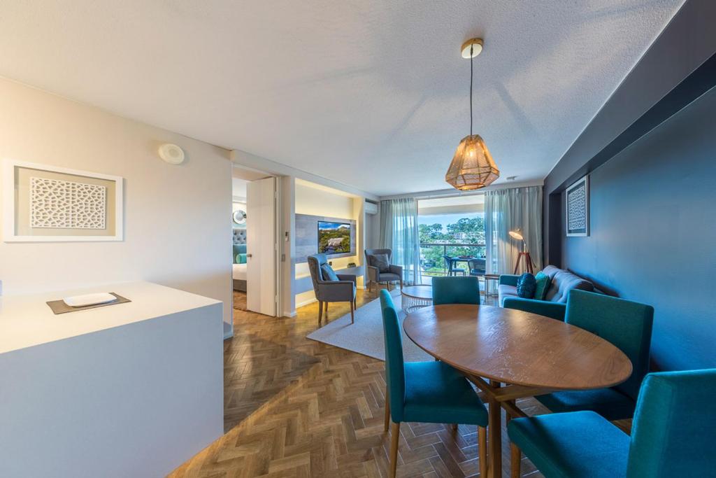 科夫斯港Accor Vacation Club at Pacific Bay的客厅里有一张桌子和蓝色的椅子