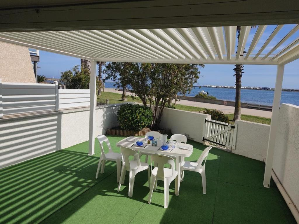 une table et des chaises blanches sous une pergola blanche dans l'établissement Gruissan - Villa T4 - Clim, WiFi, Parking, Plage 50m - 6 pers - FR-1-796-55, à Gruissan