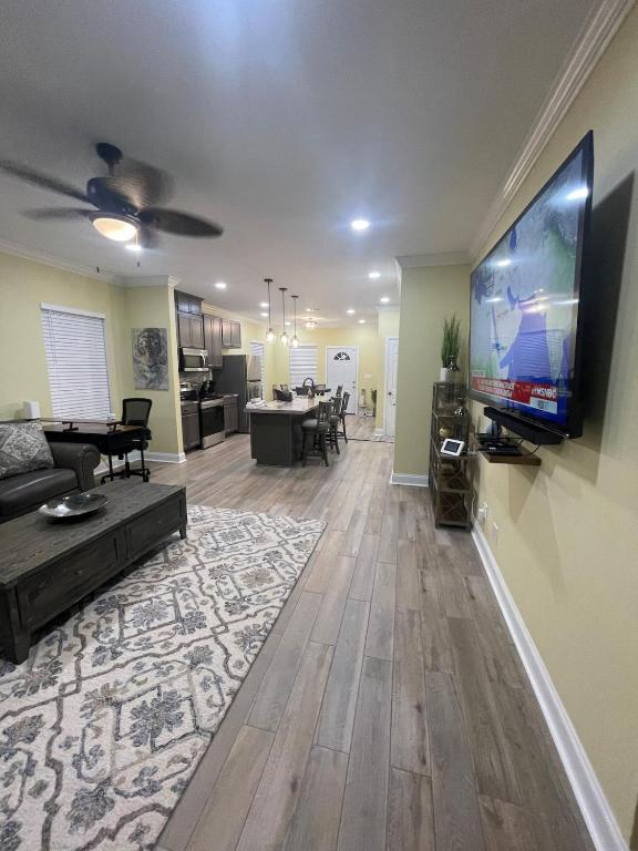 巴吞鲁日Modern Charm的客厅配有壁挂式大屏幕平面电视