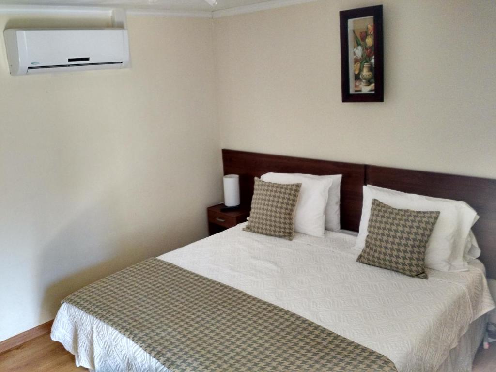een slaapkamer met een bed met witte lakens en kussens bij Hostal del Valle in Santa Cruz