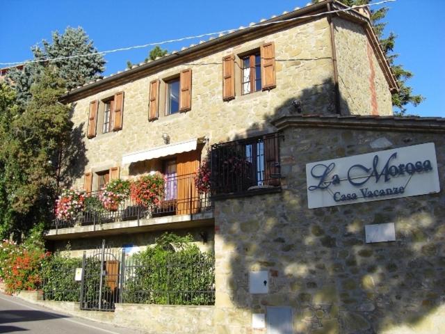 um edifício com um sinal na lateral em La Morosa em Castel Rigone